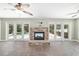 Inviting living room showcasing a stone fireplace, tile floors, ceiling fans and access to the pool area at 2908 Se 22Nd Ave, Ocala, FL 34471