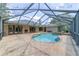 Backyard view of a luxurious pool and patio area with a screened enclosure and outdoor fireplace at 2908 Se 22Nd Ave, Ocala, FL 34471