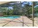 Screened in pool with brick patio and surrounding greenery at 2908 Se 22Nd Ave, Ocala, FL 34471