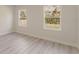 A bright bedroom features modern flooring and two windows providing natural light and views of the outdoors at 3325 Sw 165Th Loop, Ocala, FL 34473