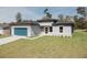 Well-maintained single-story home with modern design elements, a blue garage door, and a green lawn at 3325 Sw 165Th Loop, Ocala, FL 34473