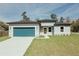 Charming single-story home featuring a modern design, blue garage door, and well-maintained lawn at 3325 Sw 165Th Loop, Ocala, FL 34473
