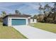 Single-story home with a blue garage door, a long concrete driveway, and lush green lawn at 3325 Sw 165Th Loop, Ocala, FL 34473