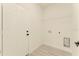 A well-lit laundry room with a door, shelving, and modern flooring, offering convenience and functionality at 3325 Sw 165Th Loop, Ocala, FL 34473