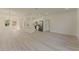 Spacious living room with light wood floors leading to a modern, all-white kitchen at 3325 Sw 165Th Loop, Ocala, FL 34473