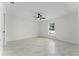 Clean, minimalist bedroom featuring a ceiling fan, natural light, and marble tile flooring at 36 Pine Radl, Ocala, FL 34472