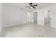 Clean, minimalist bedroom featuring a ceiling fan, natural light, and marble tile flooring at 36 Pine Radl, Ocala, FL 34472