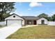 Charming single-story home featuring a two-car garage, landscaped front yard, and neutral color palette at 36 Pine Radl, Ocala, FL 34472
