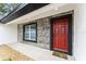 Close-up of front entrance with red door and stone features at 36 Pine Radl, Ocala, FL 34472