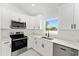 Bright kitchen featuring white cabinets, stainless steel appliances and modern countertops at 36 Pine Radl, Ocala, FL 34472