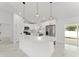 Bright, open kitchen with white cabinets, a large island, stainless steel appliances and marble tile flooring at 36 Pine Radl, Ocala, FL 34472