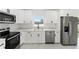 Kitchen with white cabinetry, stainless steel appliances, and stone countertops at 36 Pine Radl, Ocala, FL 34472