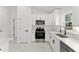 A bright kitchen featuring white cabinetry, marble countertops, and modern stainless steel appliances at 36 Pine Radl, Ocala, FL 34472