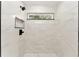 Bright walk-in shower showcasing marble tiling, a geometric floor, and shower window at 36 Pine Radl, Ocala, FL 34472