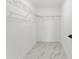Bright walk-in closet featuring wire shelving and marble-patterned flooring at 36 Pine Radl, Ocala, FL 34472