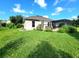 Well-maintained backyard featuring an enclosed sunroom, lush lawn, and beautiful landscaping at 3803 Se 6Th Ave, Ocala, FL 34480