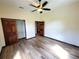 Spacious bedroom with wood-look flooring, closet with wood doors, and ceiling fan at 3803 Se 6Th Ave, Ocala, FL 34480