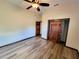 Spacious bedroom with wood-look flooring, ceiling fan, and closet with wood doors at 3803 Se 6Th Ave, Ocala, FL 34480