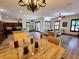 Open-concept dining and living space with an elegant chandelier, hardwood floors, and bright natural light at 3803 Se 6Th Ave, Ocala, FL 34480