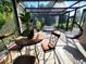 Bright sunroom with brick floor, dining table, hanging chair, and relaxing seating at 3803 Se 6Th Ave, Ocala, FL 34480