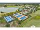 Aerial view showcases the community's tennis and pickleball courts near a lake and golf course at 4474 Nw 53Rd Ave Rd, Ocala, FL 34480