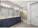 Bathroom featuring double sinks, modern fixtures, and a glass-enclosed shower with tile surround at 4474 Nw 53Rd Ave Rd, Ocala, FL 34480