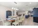 Open-concept dining area features a rustic table, modern chandelier, and seamless flow into the kitchen and living spaces at 4474 Nw 53Rd Ave Rd, Ocala, FL 34480