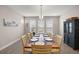 Bright dining room with a long wood table, seating for eight, a modern chandelier, and ample natural light at 4474 Nw 53Rd Ave Rd, Ocala, FL 34480