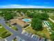 Community amenities aerial view showcasing the clubhouse, pool, shuffleboard court, parking, and greenery in a tranquil setting at 6172 Sw 101St Pl, Ocala, FL 34476