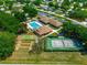 Overhead shot of community amenities: swimming pool, tennis courts, shuffleboard, and clubhouse, all nestled within a tree-filled setting at 6172 Sw 101St Pl, Ocala, FL 34476