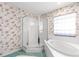 Bathroom with a floral wallpaper design, tiled flooring, glass shower, and a bathtub at 6172 Sw 101St Pl, Ocala, FL 34476