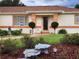 Charming single-story home featuring a manicured lawn, decorative landscaping, and inviting entryway with decorative plantings at 6172 Sw 101St Pl, Ocala, FL 34476