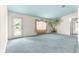 Bright living room with blue carpet, unique palm tree details, and a glass door leading to the outside at 6172 Sw 101St Pl, Ocala, FL 34476