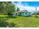 Back of home with green lawn, palm trees, and plenty of room for activities at 6773 Se 87Th St, Ocala, FL 34472