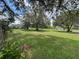 Expansive backyard featuring lush green grass and mature trees, offering ample space and a serene atmosphere at 6773 Se 87Th St, Ocala, FL 34472