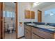 Traditional bathroom with double sinks, decorative wallpaper, and wood cabinetry at 6773 Se 87Th St, Ocala, FL 34472