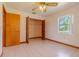 Bright bedroom features a ceiling fan, closet, and tile flooring at 6773 Se 87Th St, Ocala, FL 34472