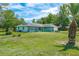 Single story home with lush green lawn, stone accents, and a two car garage at 6773 Se 87Th St, Ocala, FL 34472