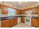 Cozy kitchen features wooden cabinets, white appliances, and a double sink under a window at 6773 Se 87Th St, Ocala, FL 34472