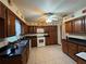Functional kitchen featuring wooden cabinets, black countertops, white appliances, and tile flooring at 6773 Se 87Th St, Ocala, FL 34472