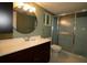 Bathroom featuring dark wood vanity cabinet, round mirror, stand-up shower with sliding glass doors, and a toilet at 8655 Sw 98Th Street Rd # G, Ocala, FL 34481