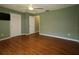 Bedroom with wood floors, ceiling fan, and three doors leading to different areas at 8655 Sw 98Th Street Rd # G, Ocala, FL 34481