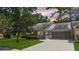 Exterior view of the house featuring a large driveway, lawn, covered porch, and an attached garage at 8655 Sw 98Th Street Rd # G, Ocala, FL 34481