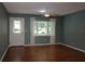 A bright living room with a ceiling fan, wood flooring, and a large window offering plenty of natural light at 8655 Sw 98Th Street Rd # G, Ocala, FL 34481
