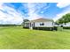 Back exterior view of home showing screened in porch and lush green lawn at 8689 Se 141St Street Rd, Summerfield, FL 34491