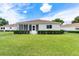 Back exterior view of home showing screened in porch and lush green lawn at 8689 Se 141St Street Rd, Summerfield, FL 34491