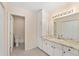 Bright bathroom featuring a vanity with granite countertop, built-in storage, and open doorway to separate toilet area at 8689 Se 141St Street Rd, Summerfield, FL 34491