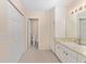 Bright bathroom featuring a vanity with granite countertop, built-in storage, and open doorway to separate toilet area at 8689 Se 141St Street Rd, Summerfield, FL 34491
