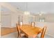 Open-concept dining area with a wooden table and chairs, chandelier lighting, and neutral wall color at 8689 Se 141St Street Rd, Summerfield, FL 34491