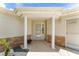 Welcoming front entrance with white columns, brick accents, and a storm-protected front door at 8689 Se 141St Street Rd, Summerfield, FL 34491